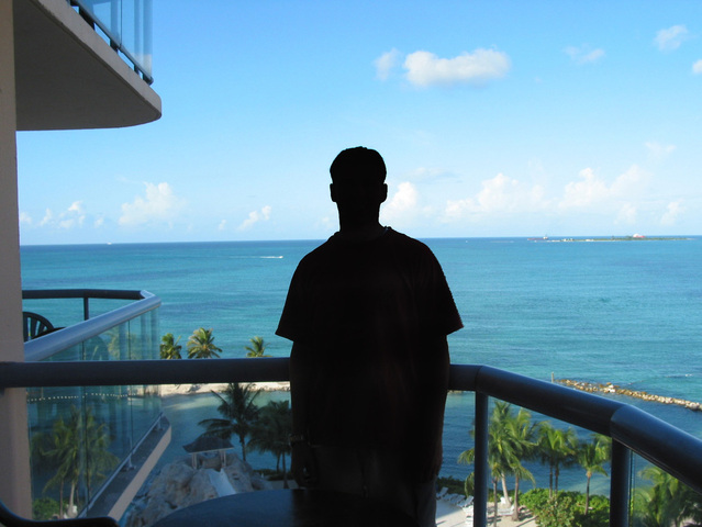Muž pozerá z balkóna, more
